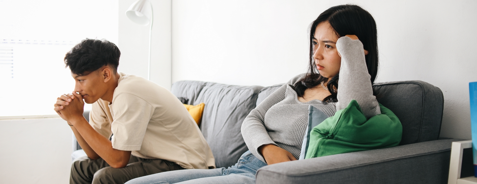 an unhappy couple sat on a sofa