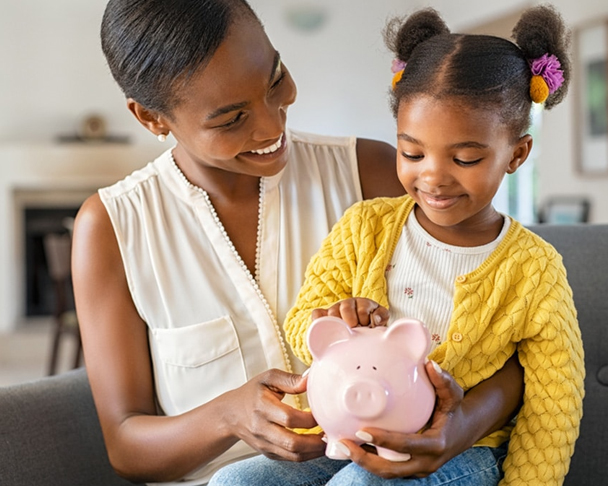 Mum and daughter holding piggy bank